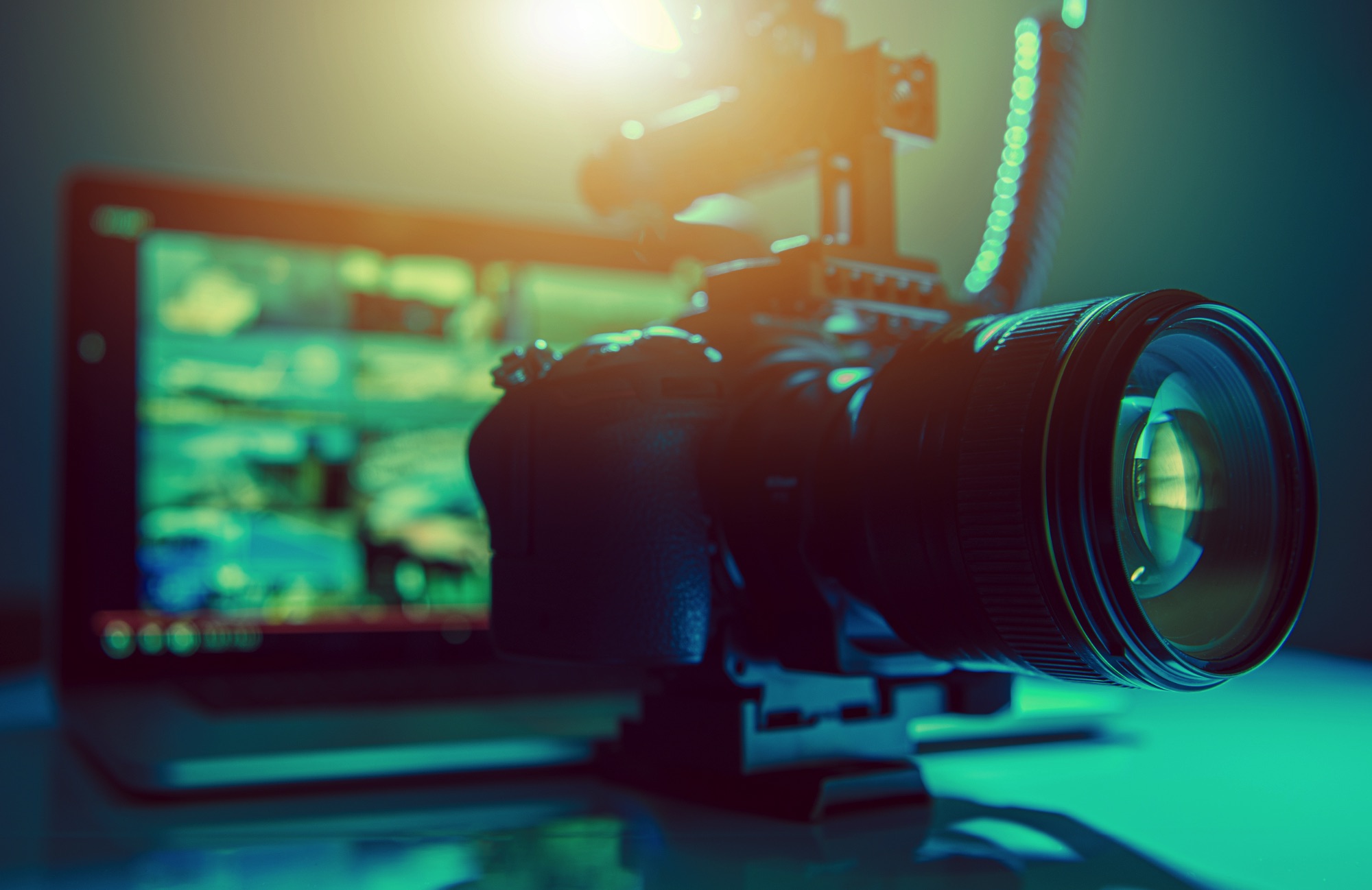 A professional video camera sitting in front of a monitor in green ambient lighting professional video production services Edmonton Calgary Alberta Canada